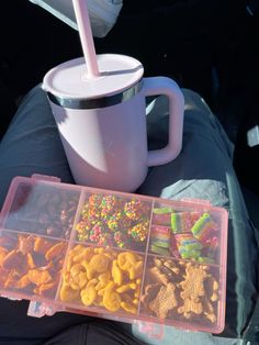 a cup with a straw and some cereal in it next to two plastic containers filled with food