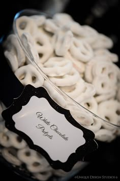 a bowl filled with white pretzels sitting on top of a black tablecloth