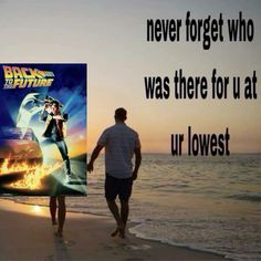 two people walking on the beach with a poster in front of them that says back to the future