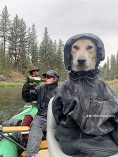 two men and a dog are in a canoe on the water, one is wearing a raincoat