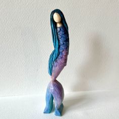 a ceramic figurine of a mermaid holding a ball