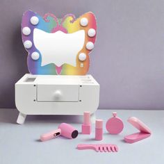 an assortment of toys including a mirror, combs and hairdryer on a table