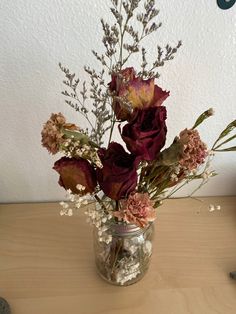 a vase filled with flowers on top of a wooden table