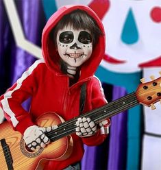 a child in skeleton makeup playing a guitar