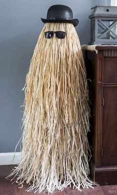 a hat and sunglasses are on top of a long, shaggy wig in front of a dresser