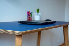 a laptop computer sitting on top of a blue table next to pens and pencils