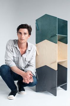 a man kneeling down next to some shelves