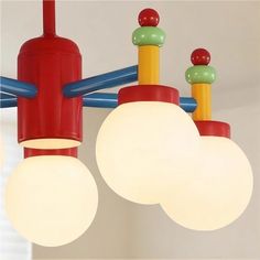 three lights are hanging from the ceiling in a room with white walls and blue pipes