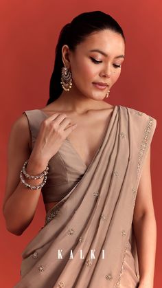 Our earthy beige crepe silk saree features luminous intricate embroidery, that will spark joy in your ethnic wardrobe.
Adorned with accents of cutdana, stone and beads, this stunning piece is ideal for special occasions, cocktail parties and festive events.