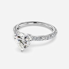 a heart shaped diamond ring with diamonds on the band and side stones in white gold