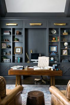 an office with built - in bookcases, leather chairs and a wooden desk