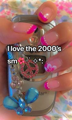 a person holding a cell phone with pink and blue nail designs on the front, and an i love the 2000's symbol on the back