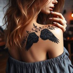 the back of a woman's shoulder with two black birds and flowers on it