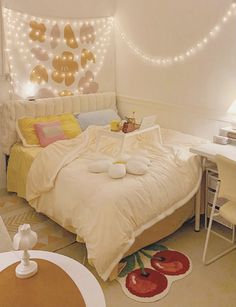 a bed room with a neatly made bed and some lights on the wall above it