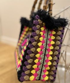 two crocheted bags hanging from a hook