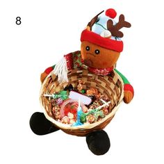 a stuffed animal sitting in a basket filled with candies and other holiday treats on a white background