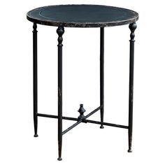 an iron table with black marble top and metal legs, isolated against a white background