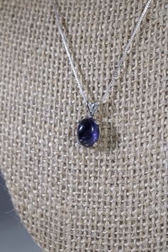 This is a minimalist, delicate iolite gemstone pendant necklace. It consists of a natural iolite cabochon, measuring 10x8mm, set in an oval, 4-prong sterling silver pendant setting. At 10x8mm, this is a small, dainty necklace for that delicate touch to your outfit. Iolite is considered to be a stone of vision and intuition. Wearers of the stone are said to be better at insight, pattern recognition, and prediction. They can more easily read people and situations. It is a stone of the third eye ch Iolite Necklace, Iolite Jewelry, Gemstone Necklace Pendant, Blue Necklace, Bridal Necklace, Dainty Necklace, Pretty Jewellery, Gemstone Pendant, Gemstone Necklace