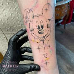 a person with a mickey mouse tattoo on their arm