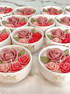 there are many small bowls with roses in them on the counter top and one is empty