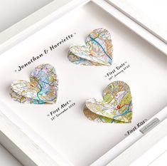 three heart shaped maps are in a white shadow box with the map and location on it