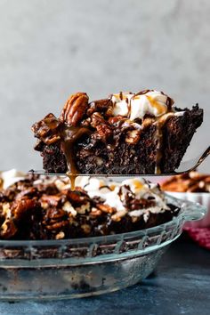 a piece of chocolate cake being drizzled with caramel and whipped cream