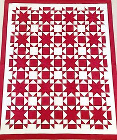 a red and white quilt with stars on it