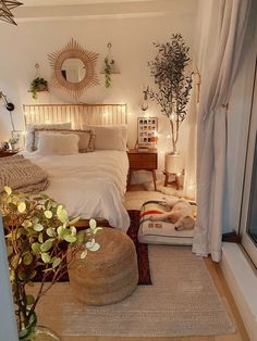 a bed room with a neatly made bed next to a window and potted plants