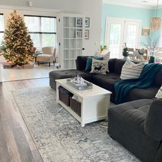 a living room filled with furniture and a christmas tree in the middle of the room