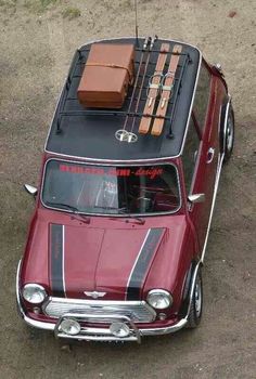 an old red car with luggage on top