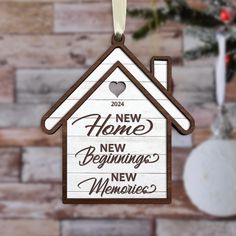 a wooden ornament hanging from a christmas tree with a house on it's side