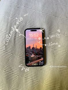 a cell phone sitting on top of a bed next to a pillow with writing above it