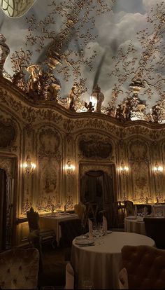 an ornate dining room with gold and white walls, chandeliers and ceiling decorations