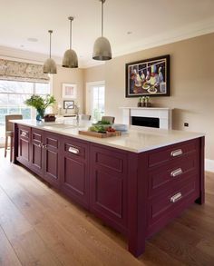 a large kitchen with an island in the middle and two pendant lights hanging from the ceiling