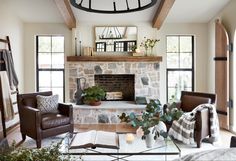 a living room filled with furniture and a fire place in front of a stone fireplace