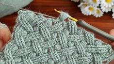 someone is crocheting the stitchs together to make a knitted afghan or shawl