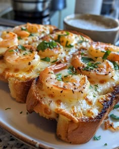 two pieces of bread topped with shrimp and cheese on top of a white plate next to a cup of coffee