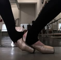 the legs and feet of a woman in ballet shoes