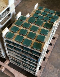 several stacks of green cupcakes sitting on top of pallets in a warehouse