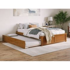 a bed sitting on top of a wooden floor next to a white rug in a bedroom