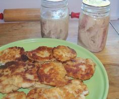 some food is sitting on a green plate and next to two jars filled with stuff