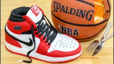 a pair of red and white sneakers next to a basketball