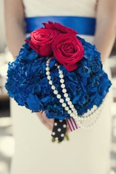 the bride's bouquet is adorned with red, white and blue flowers