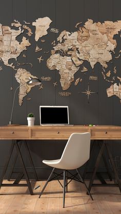 a desk with a laptop on it in front of a world map wallpaper mural