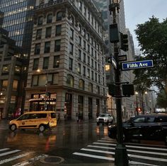 an intersection in the city at dusk with cars and people walking on the sidewalk near it