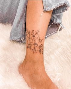 a woman's foot with a flower tattoo on her left ankle and right leg