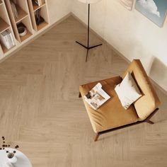 an overhead view of a living room with wood flooring and beige furniture, including a chair