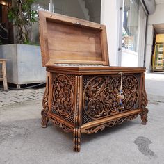 an intricately carved wooden chest on the sidewalk