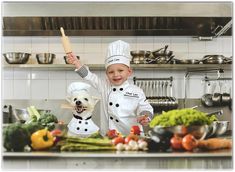 a little boy that is standing in the kitchen with a chef's hat on