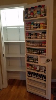 an open pantry door in the middle of a room with shelves full of food and condiments